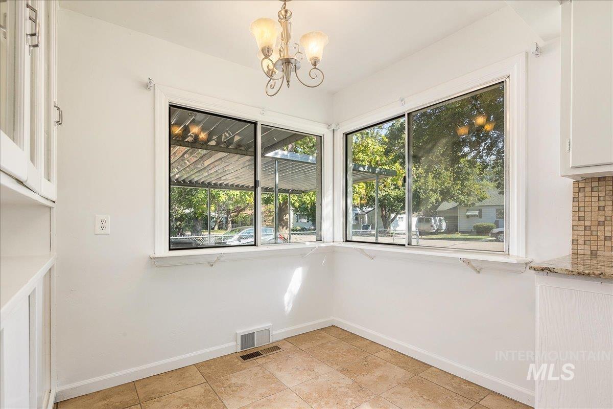 Unfurnished dining area with a chandelier and light tile patterned flooring