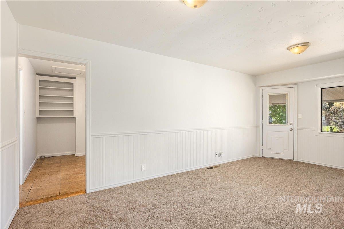 Unfurnished bedroom featuring carpet floors and wainscoting