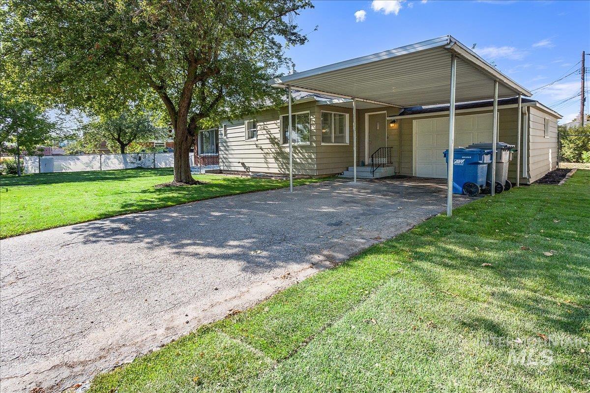 View of front of home featuring asphalt driveway and a carport