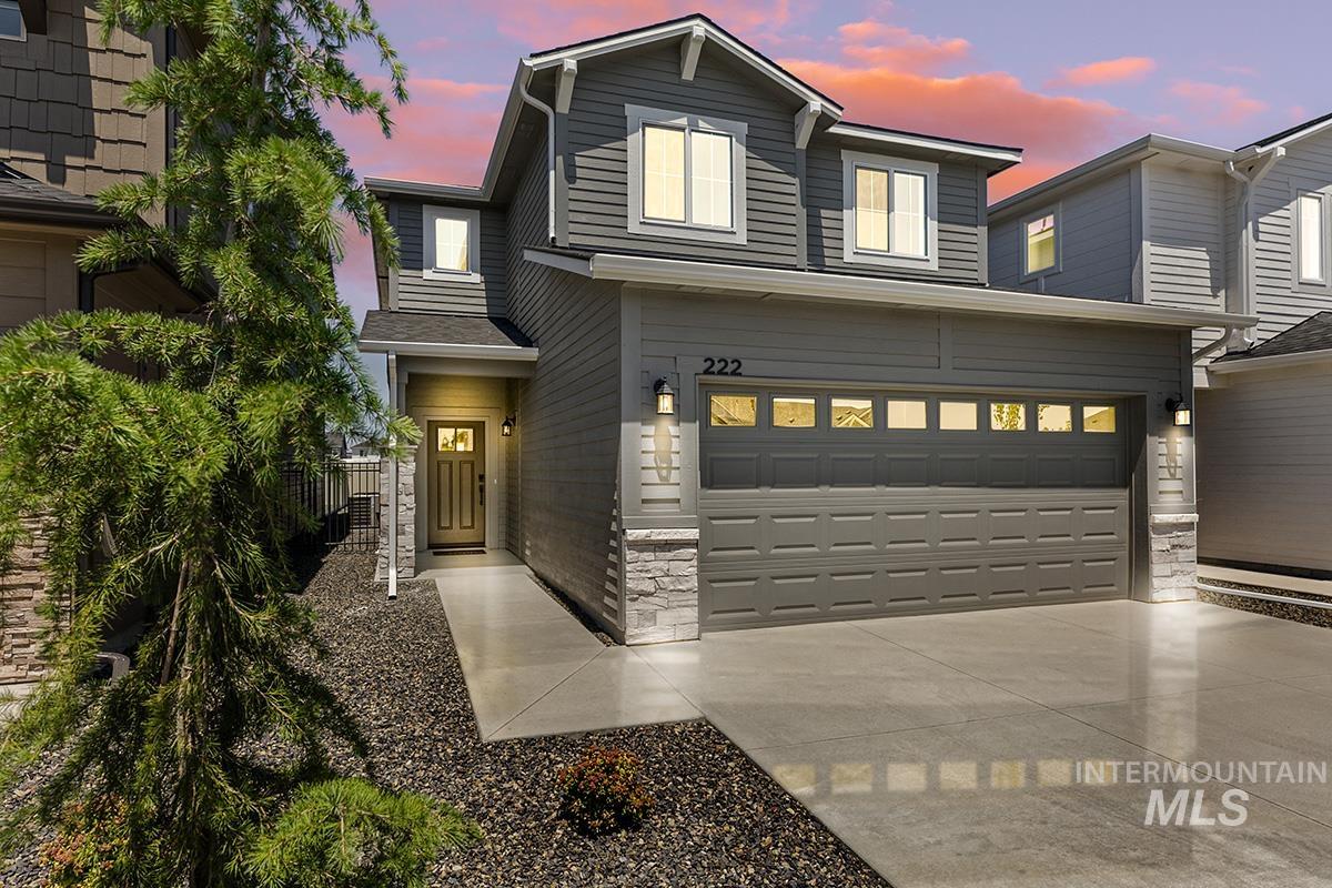 View of front of property with stone siding, concrete driveway, and an attached garage