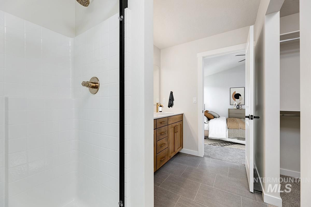 Bathroom with a shower stall, ensuite bathroom, vanity, and a spacious closet