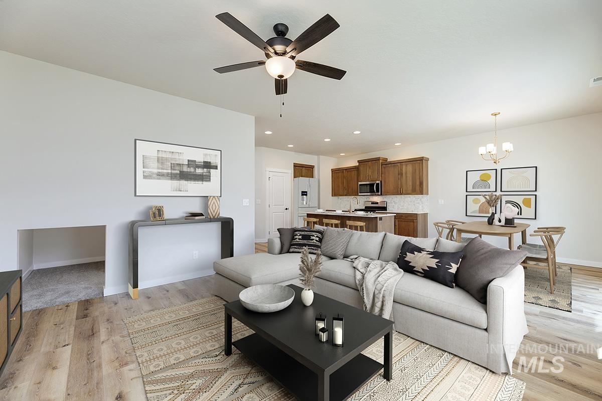 Living area with ceiling fan, a chandelier, recessed lighting, and light wood-style flooring