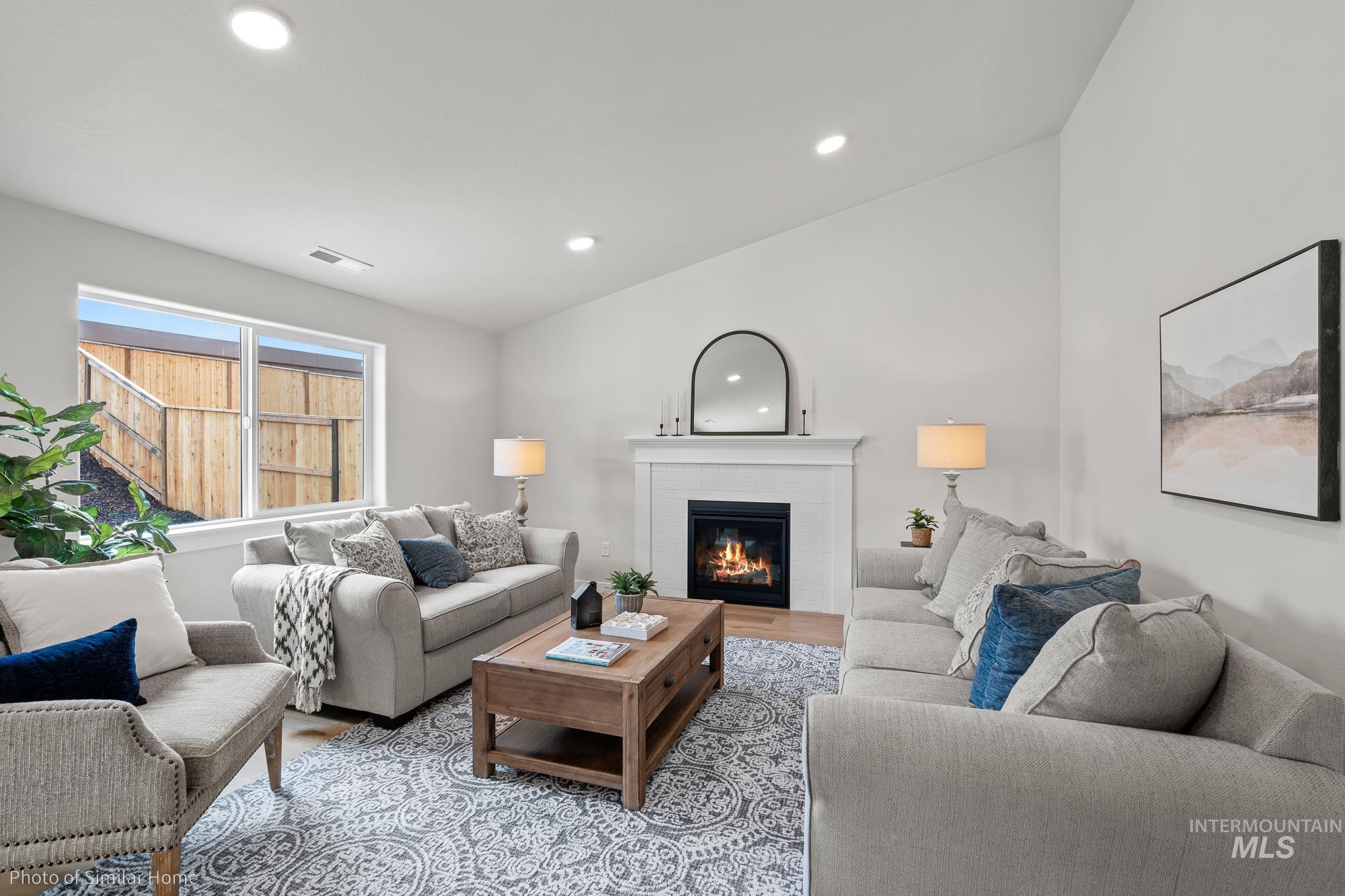 Living area with recessed lighting, a glass covered fireplace, and wood finished floors