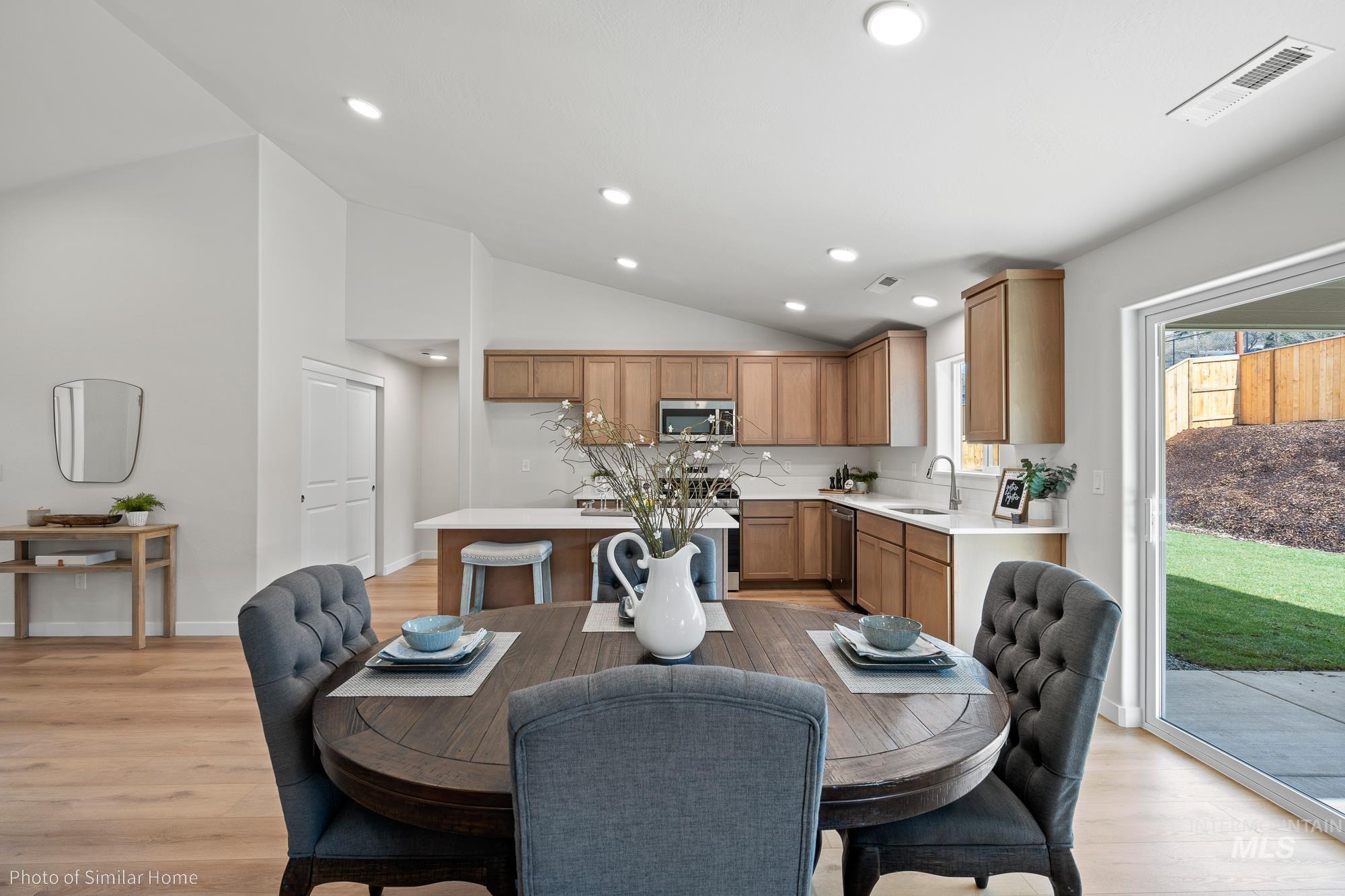 Dining room with recessed lighting, light wood-type flooring, and high vaulted ceiling