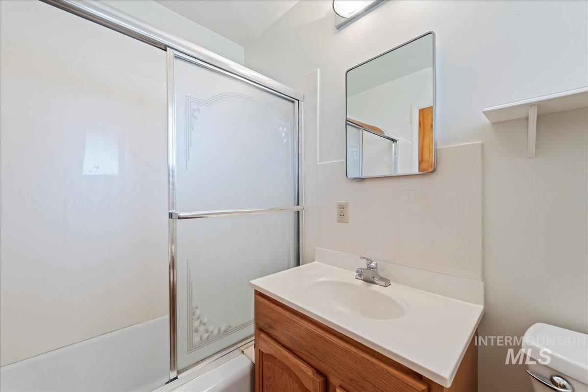 Bathroom featuring enclosed tub / shower combo and vanity
