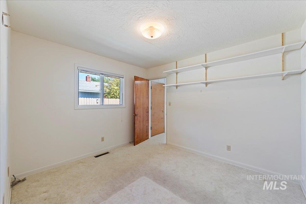 Unfurnished bedroom featuring carpet flooring and a textured ceiling
