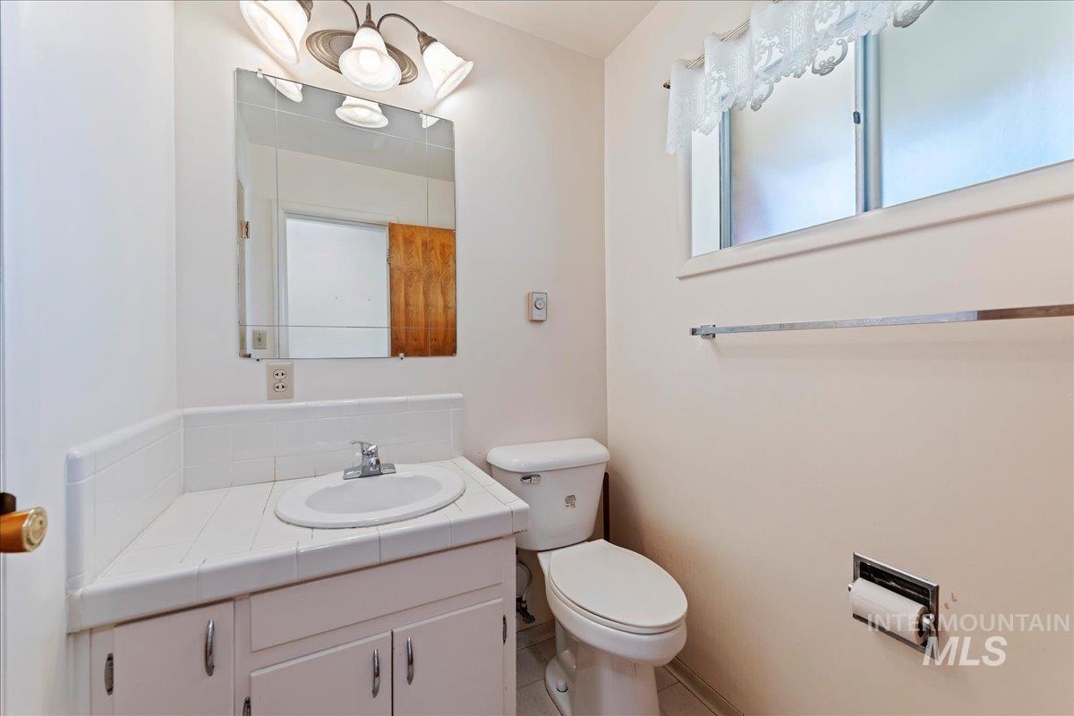 Half bath with vanity and tile patterned flooring