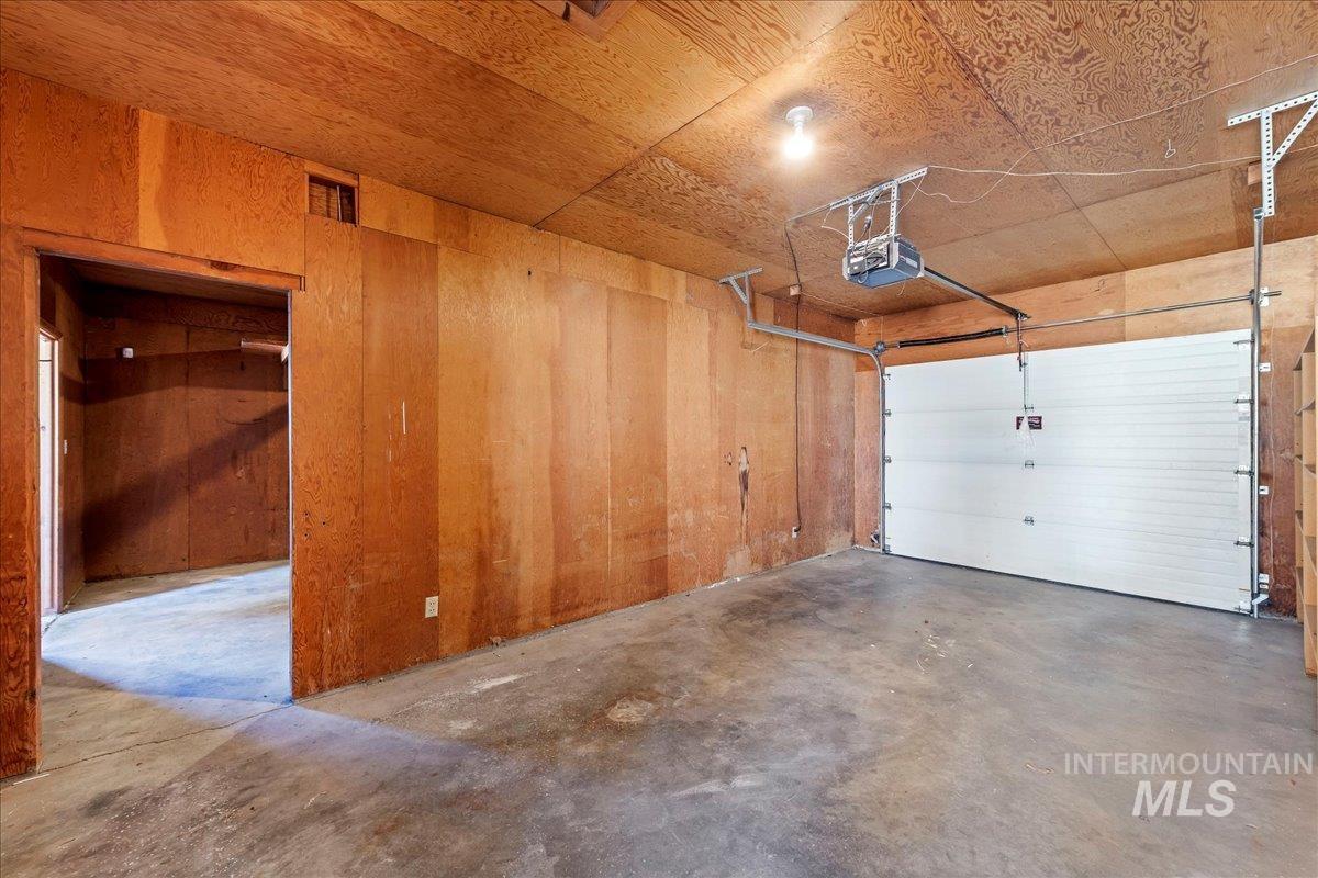 Garage featuring a garage door opener and wood walls