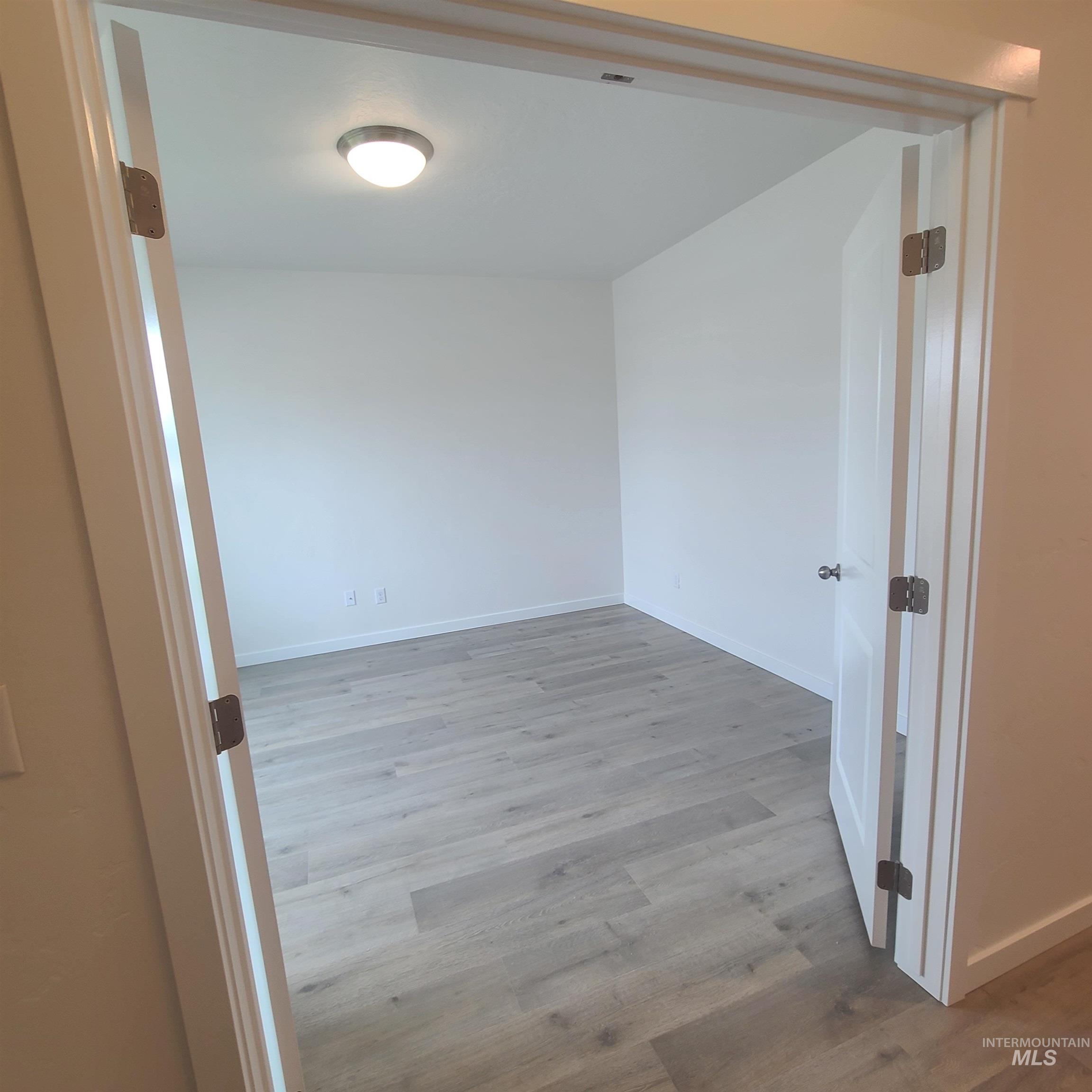 Unfurnished room with light wood-style floors and baseboards