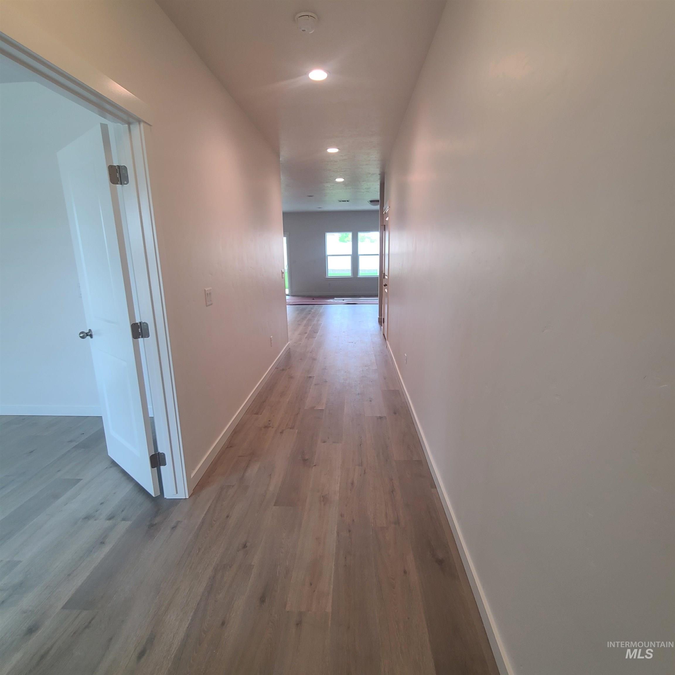 Corridor featuring light wood-style floors and recessed lighting