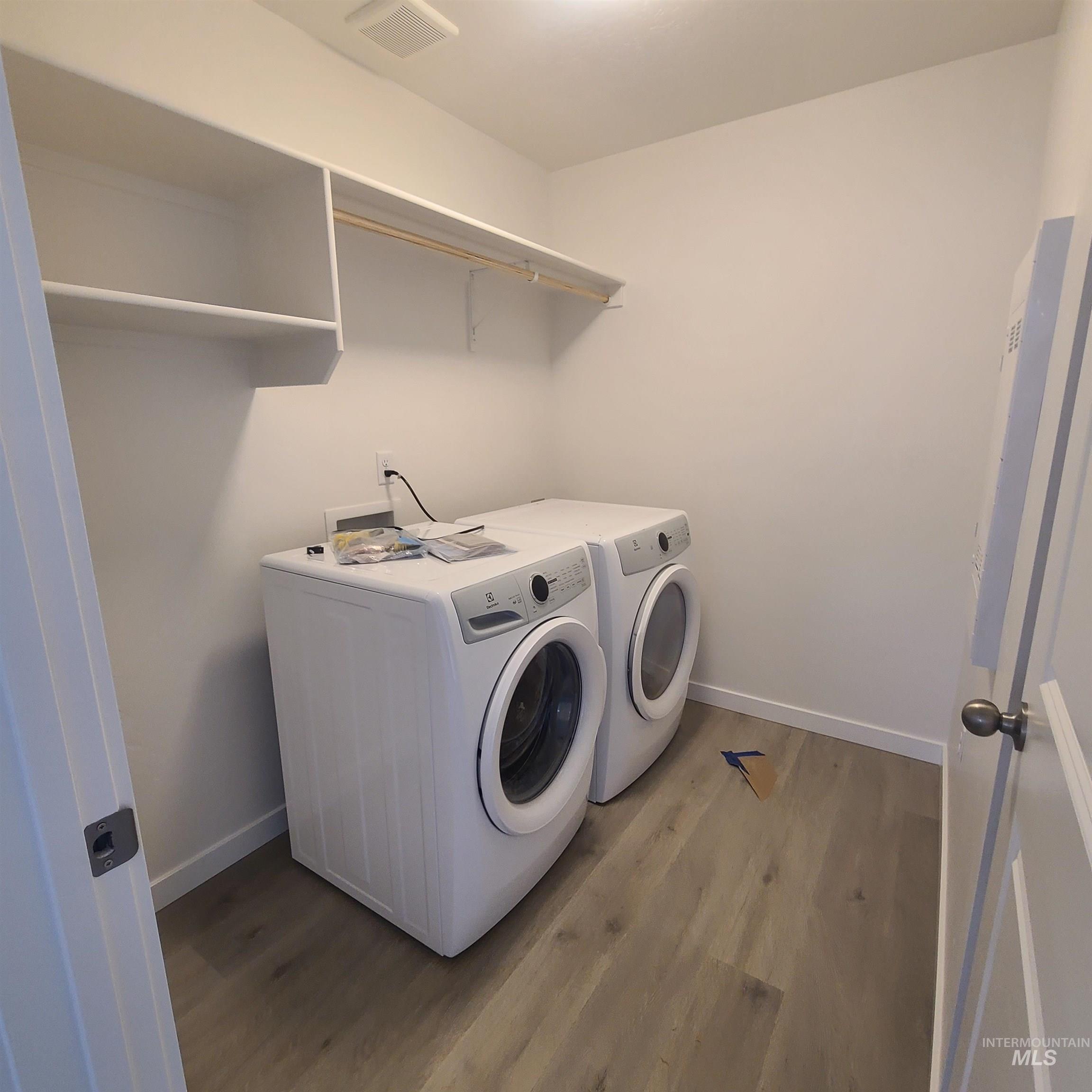 Laundry area featuring light wood-type flooring and independent washer and dryer