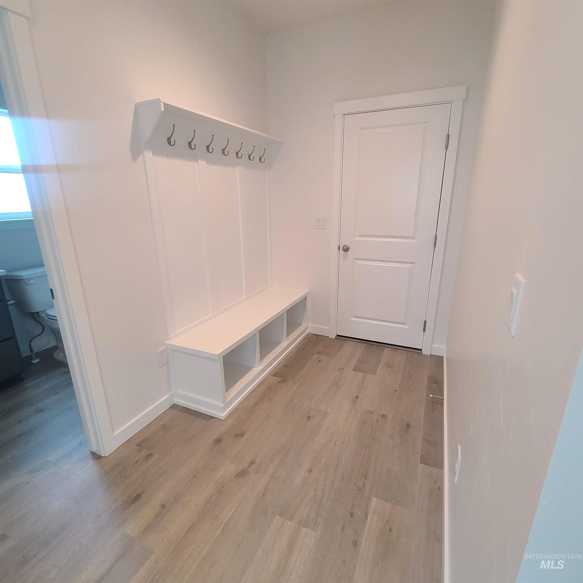 Mudroom with light wood-style flooring and baseboards