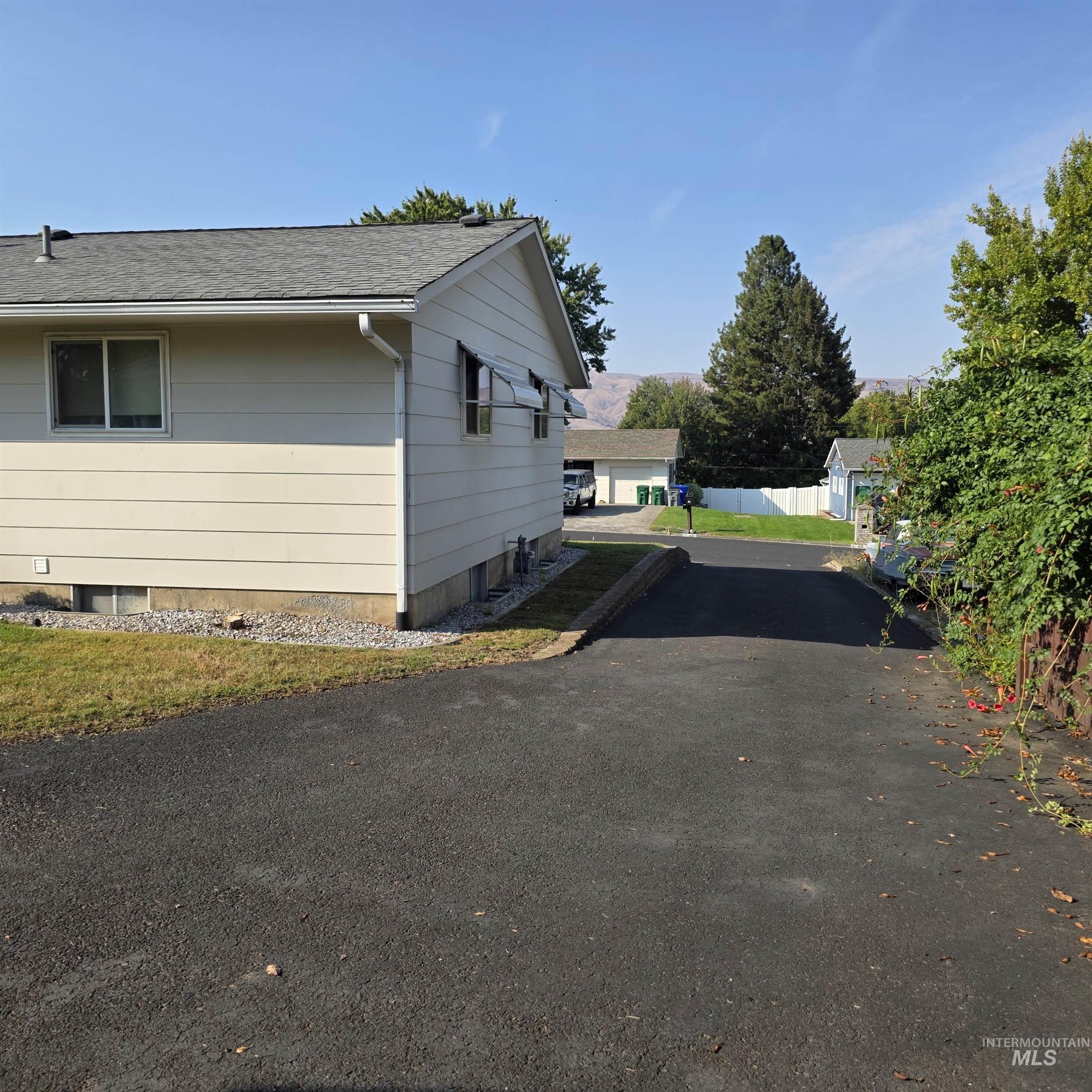 View of side of property with roof with shingles