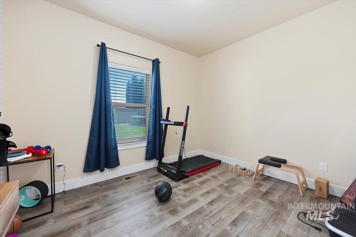 Workout room with wood finished floors and baseboards