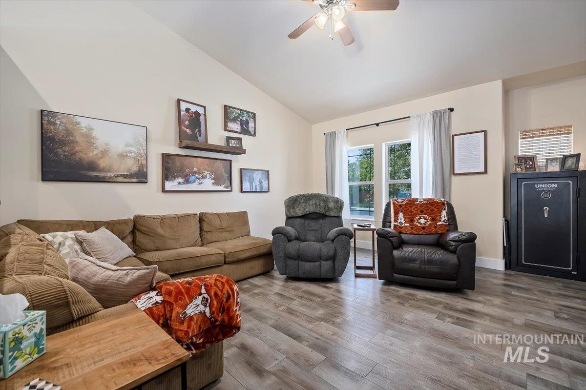 Living area featuring wood finished floors, ceiling fan, and high vaulted ceiling