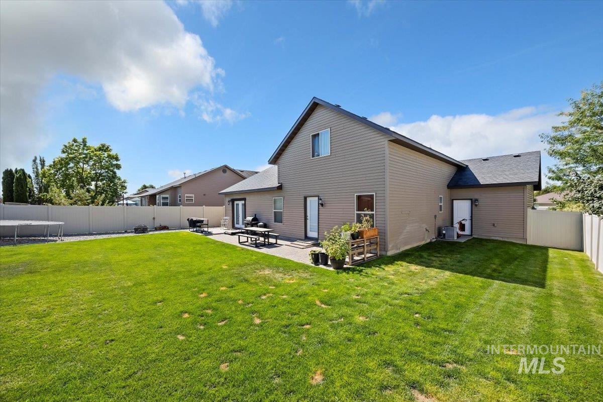 Back of property featuring a fenced backyard and a patio