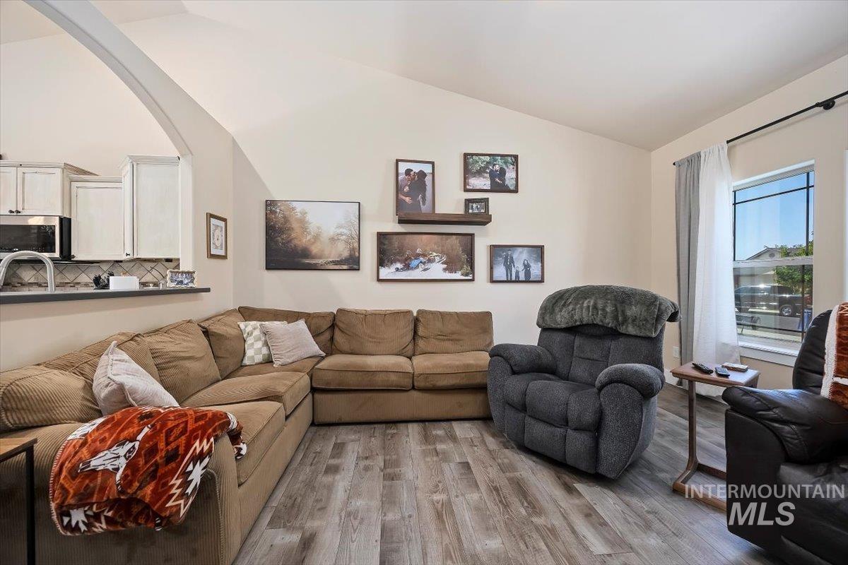 Living room with vaulted ceiling and wood finished floors