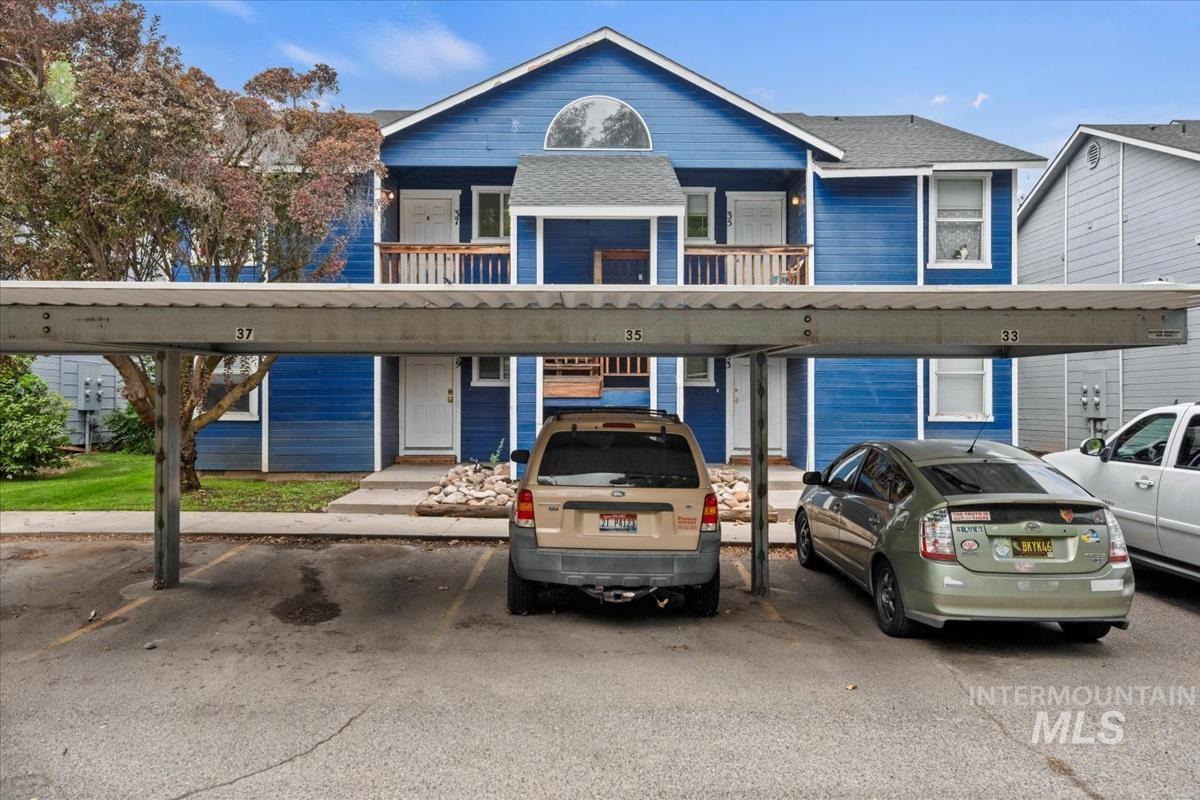 View of front of property featuring covered parking and a balcony