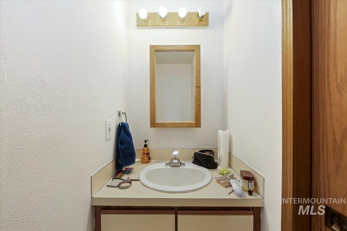 Bathroom with vanity and a textured wall