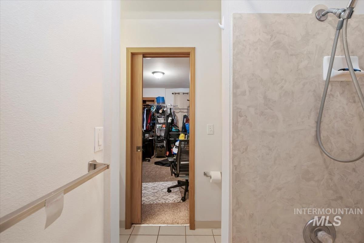 Hall featuring light colored carpet and light tile patterned floors