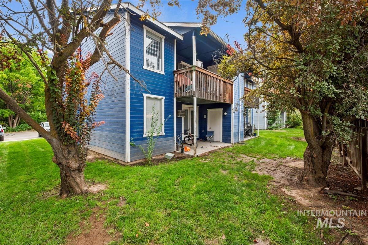 Back of property featuring a yard, a patio, and a deck