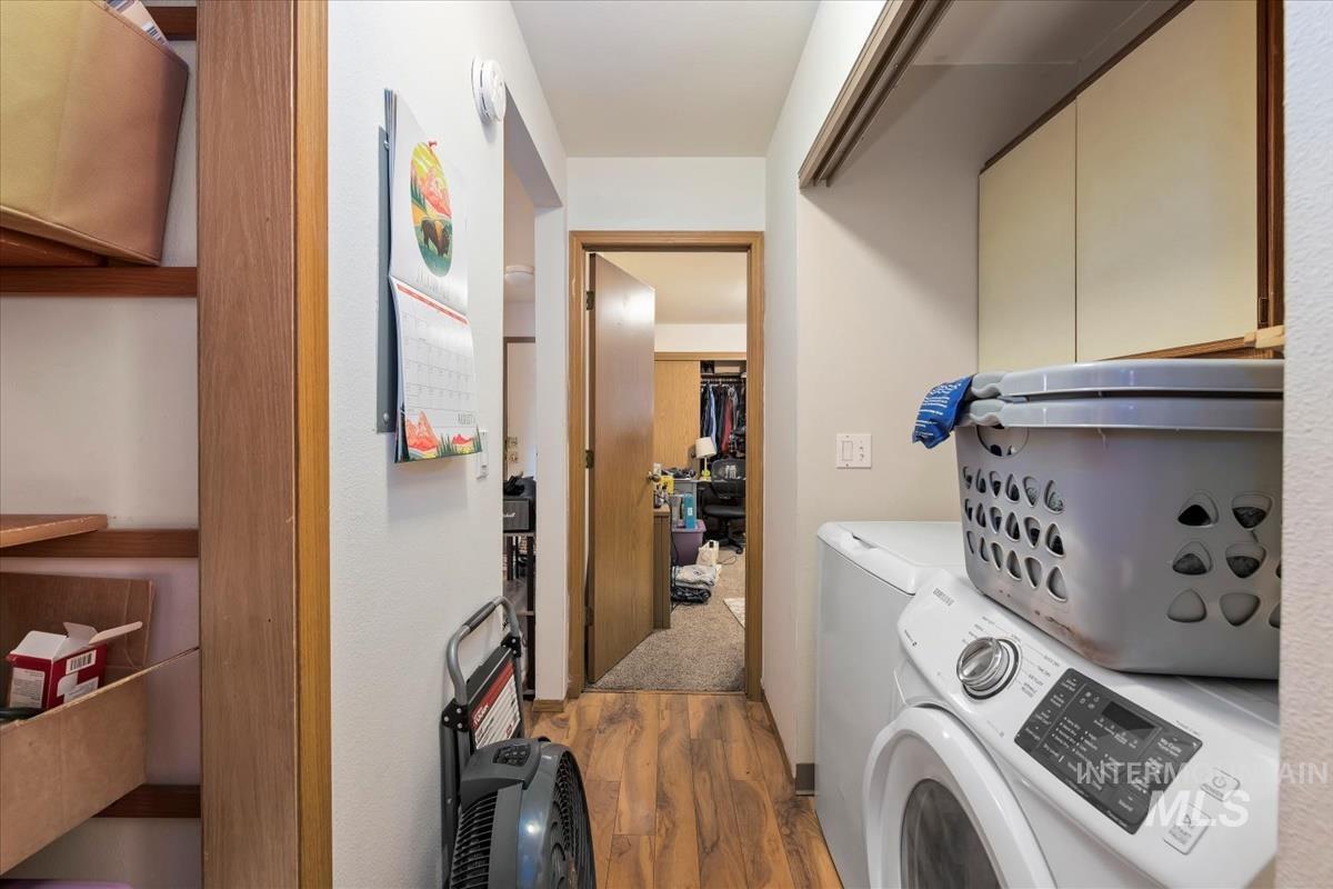 Laundry area with dark wood-type flooring and washing machine and dryer