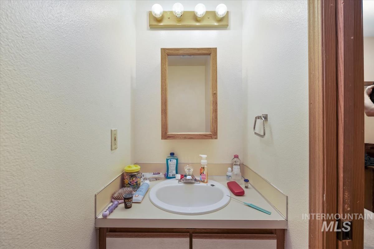 Bathroom with vanity and a textured wall