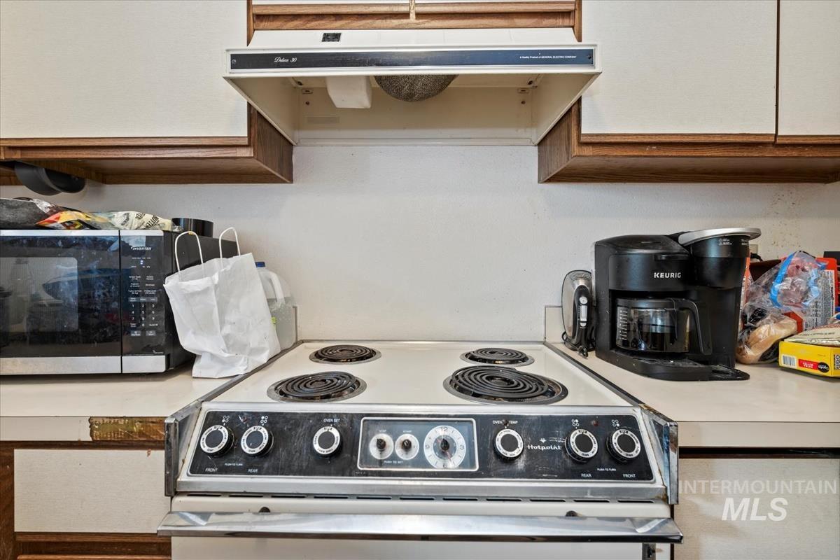 Kitchen featuring white electric range oven, extractor fan, and light countertops