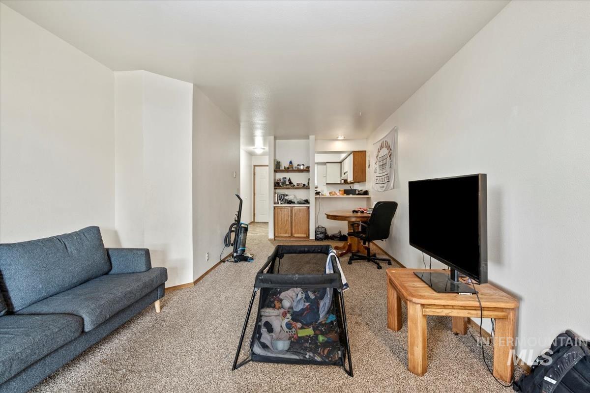 Living area featuring light carpet and baseboards