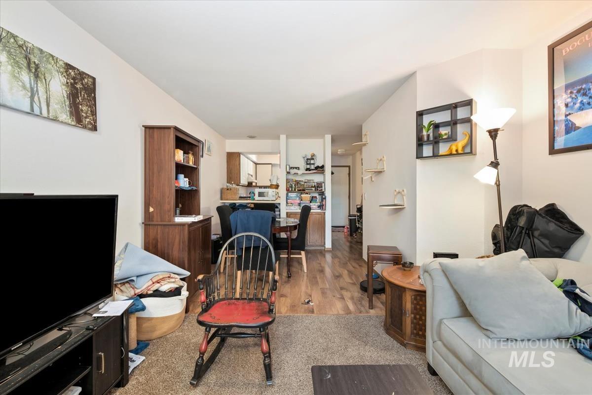 Living area with light colored carpet and light wood finished floors