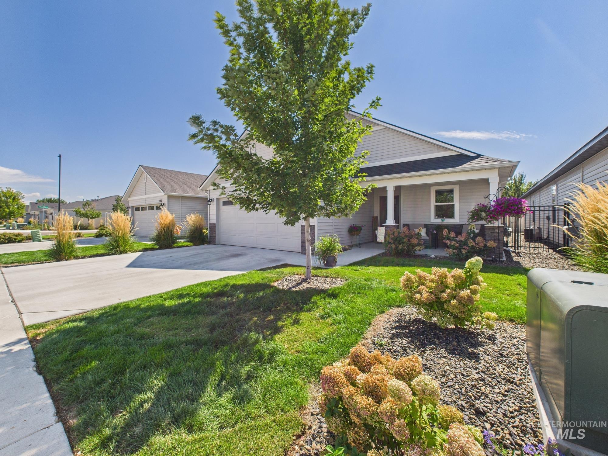 View of front of property with concrete driveway, covered porch, and a garage