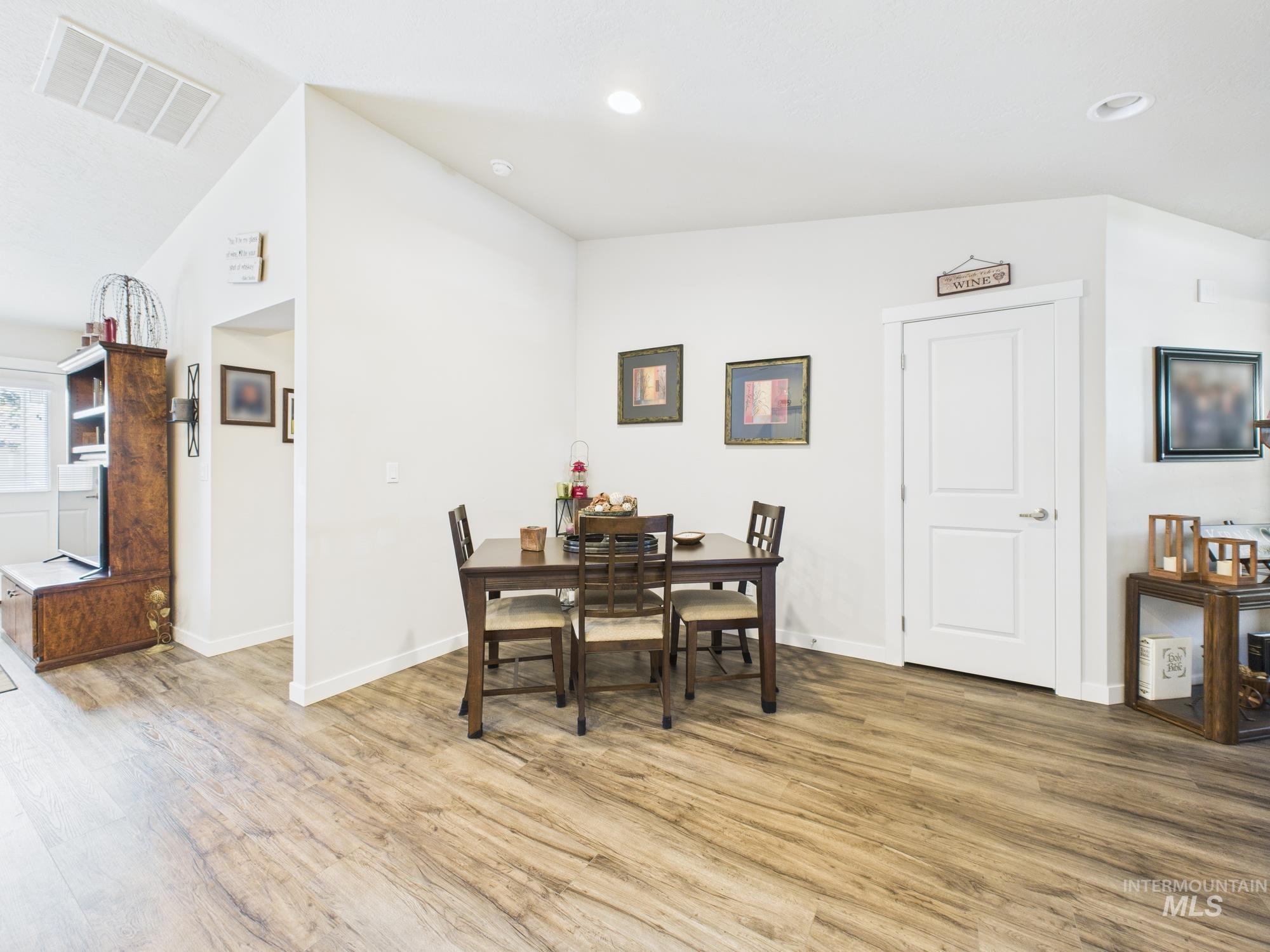 Dining space with lofted ceiling, light wood-style floors, and recessed lighting