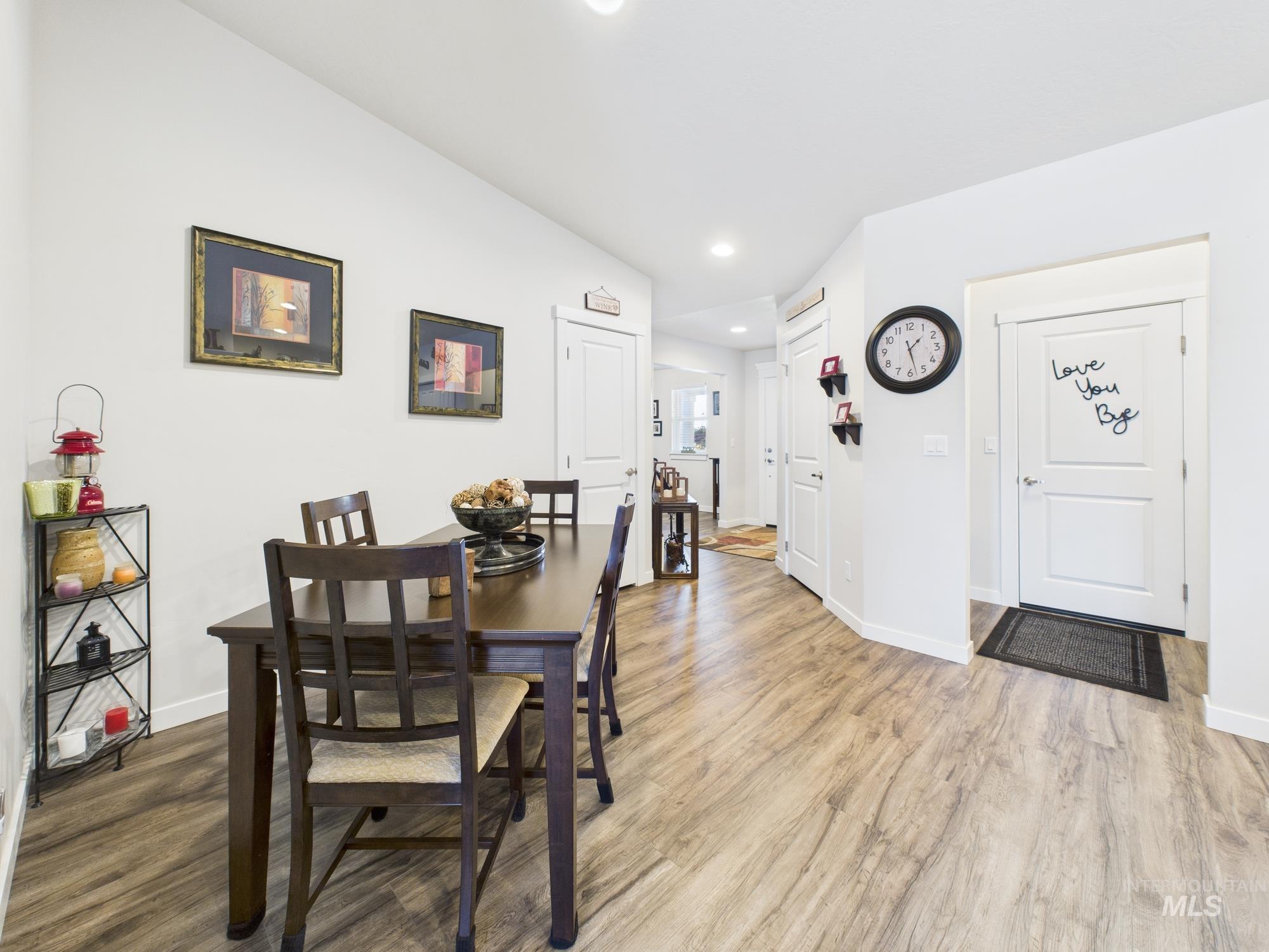 Dining room with wood finished floors and recessed lighting
