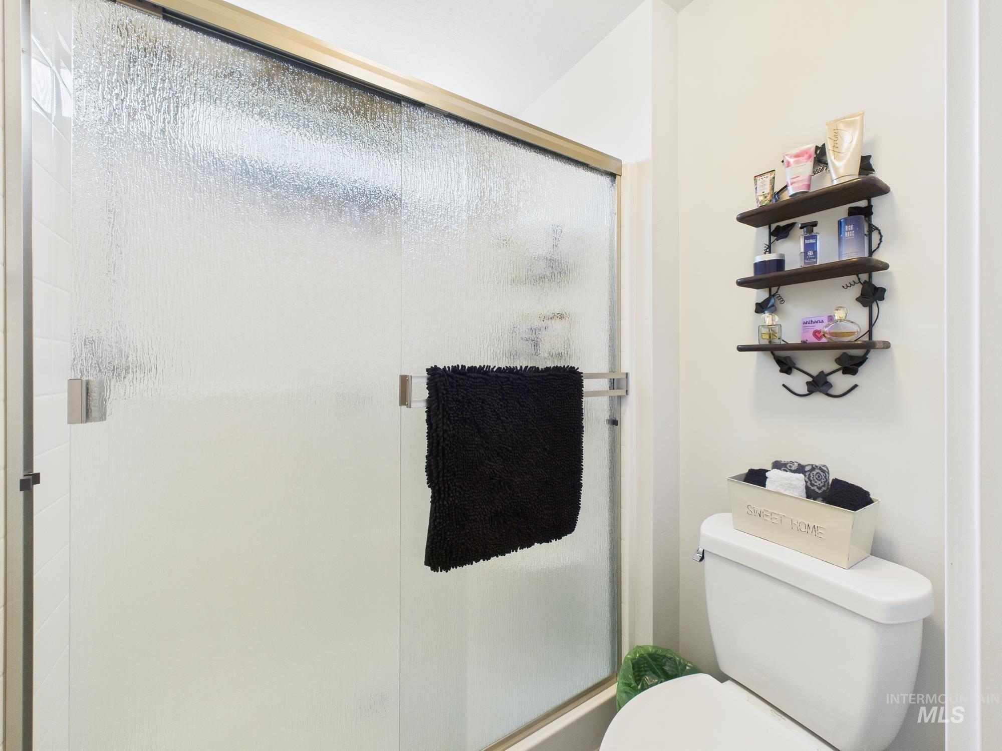 Full bath featuring a stall shower and toilet