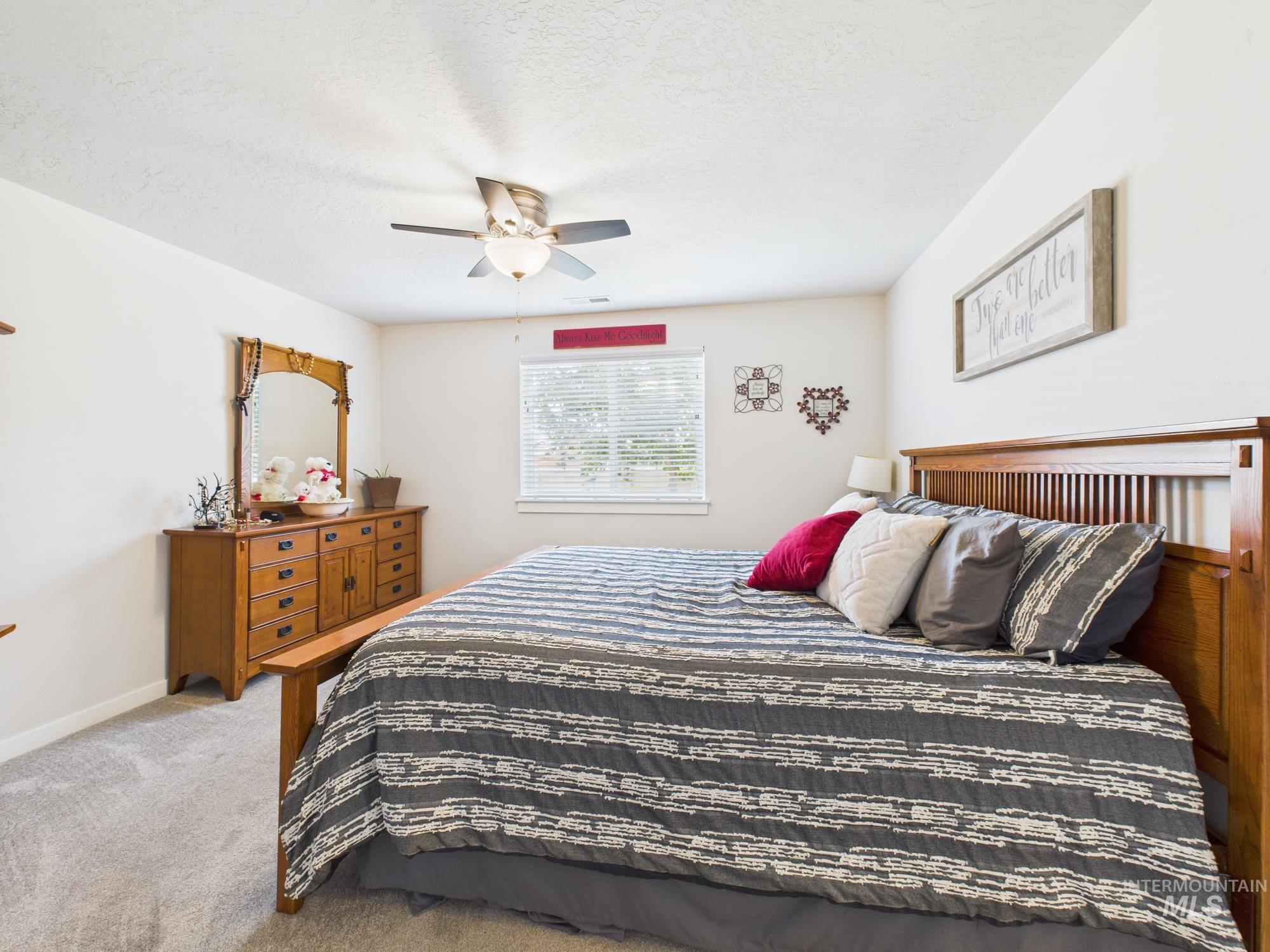 Bedroom featuring carpet, ceiling fan, and a textured ceiling