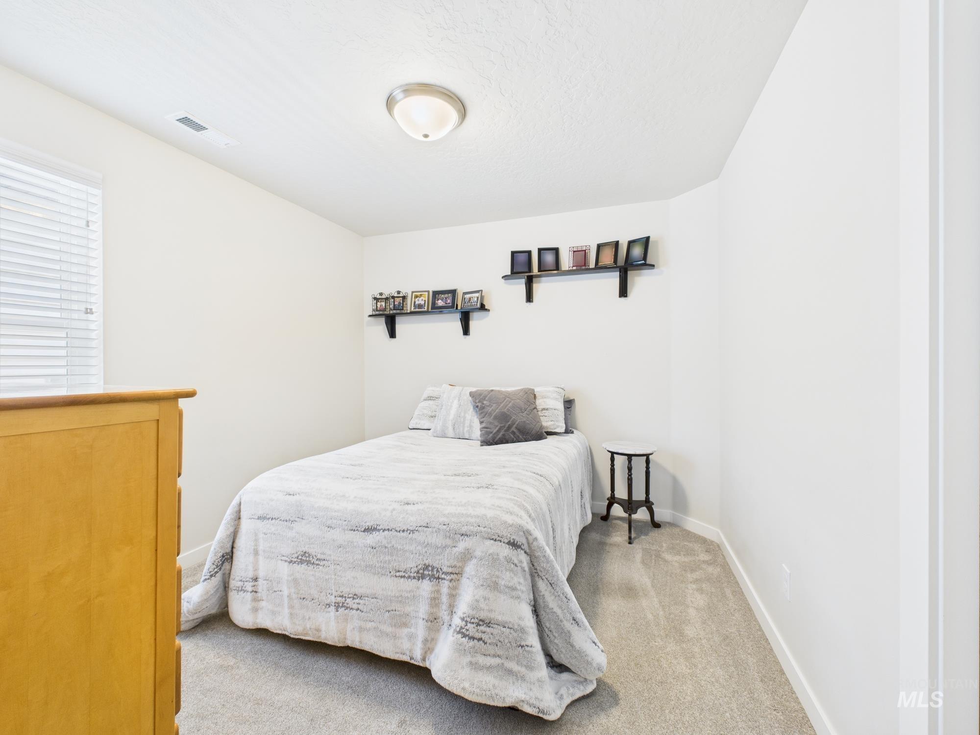 Bedroom with light carpet and a textured ceiling