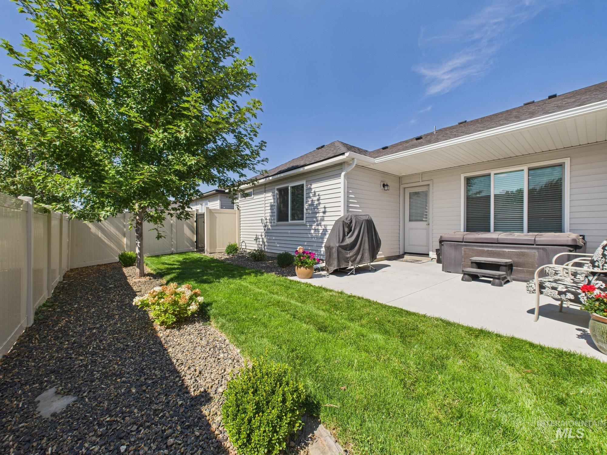 Back of property featuring a hot tub, a fenced backyard, and a patio