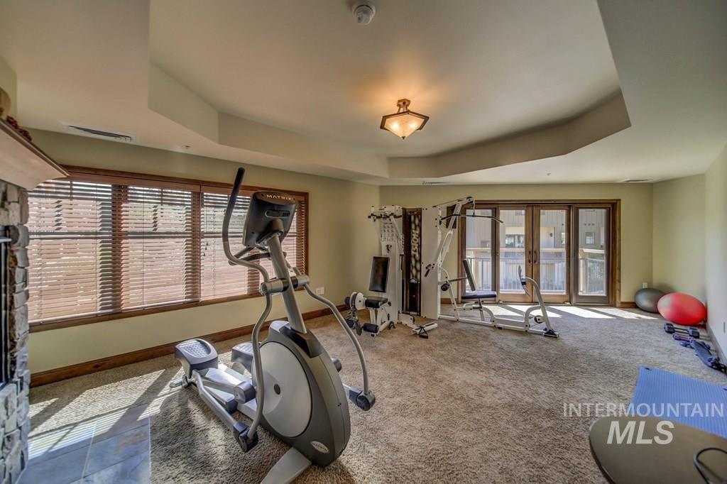 Workout area featuring carpet, french doors, and a tray ceiling