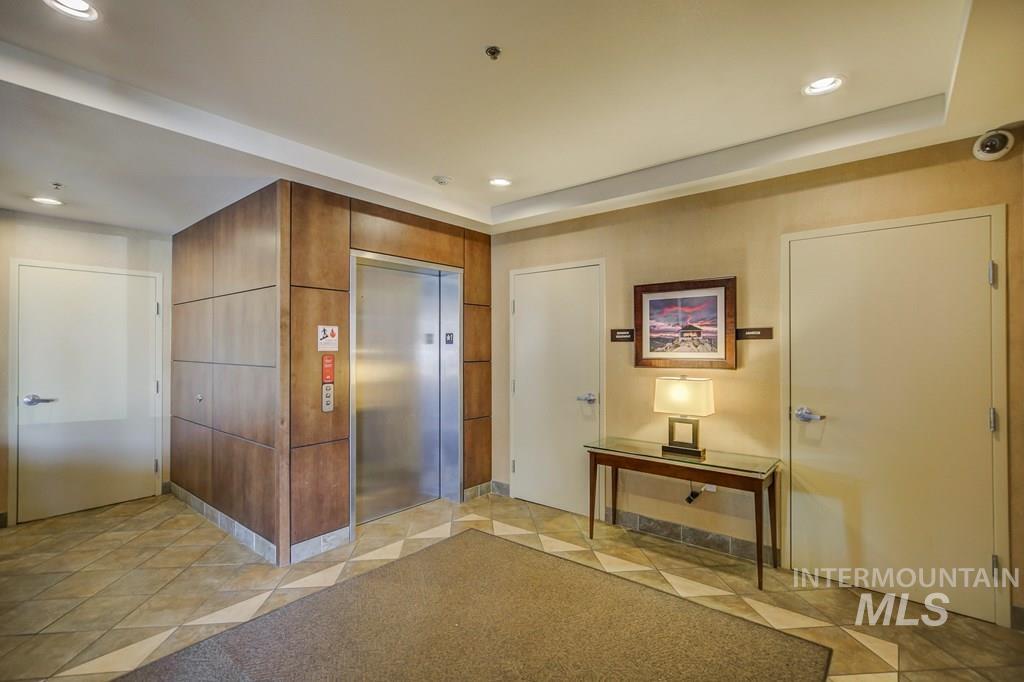 Entryway featuring elevator, recessed lighting, and a tray ceiling