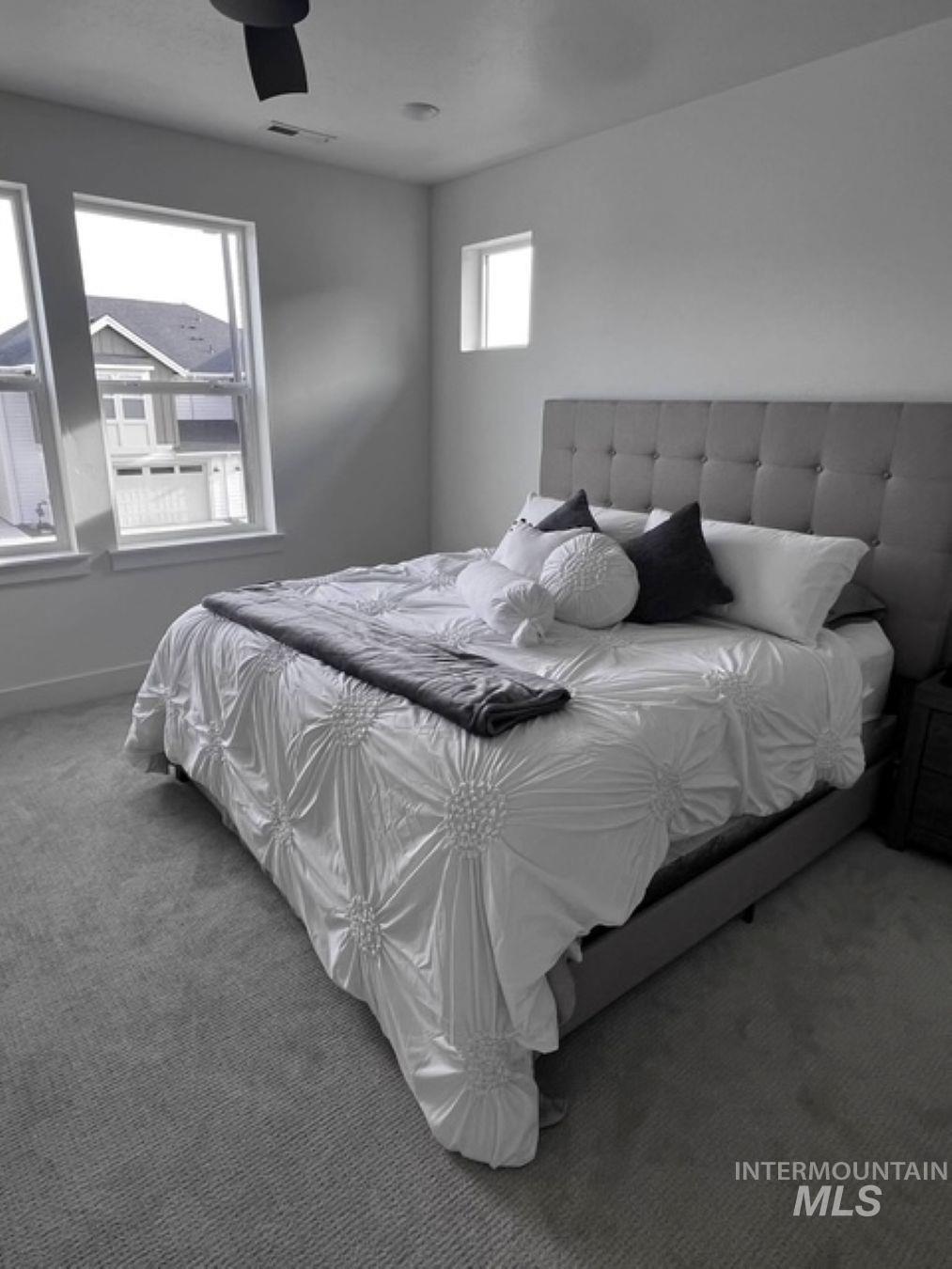 Carpeted bedroom featuring a ceiling fan