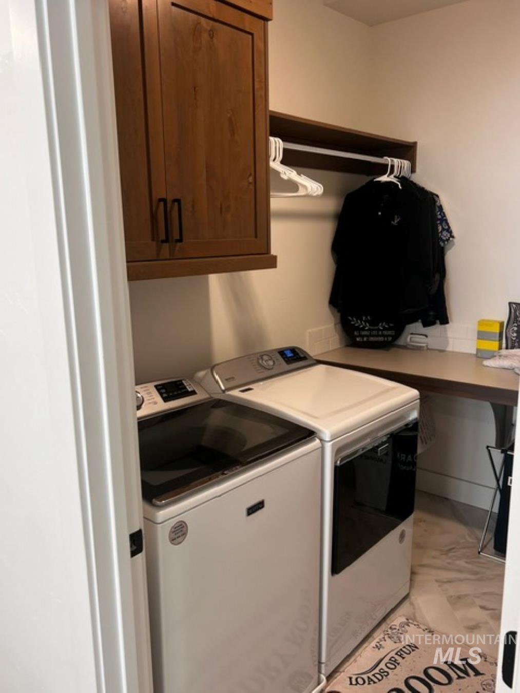 Washroom featuring cabinet space and washing machine and clothes dryer