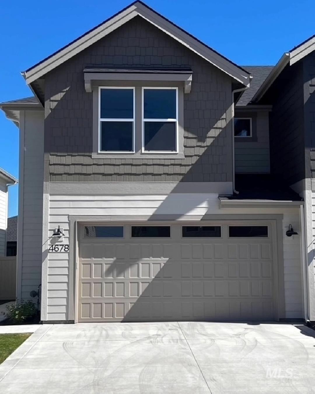 View of side of home with a garage and driveway