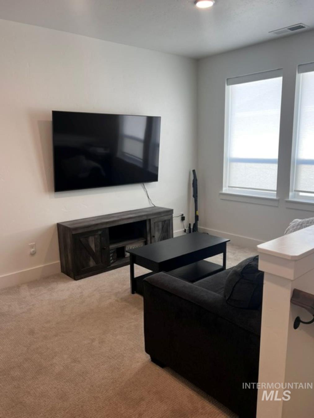 Living area featuring light carpet and recessed lighting