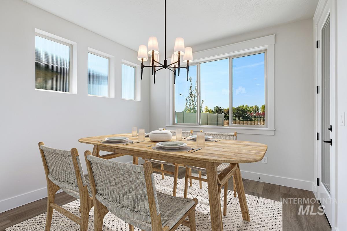 Dining space with dark wood-type flooring and a chandelier