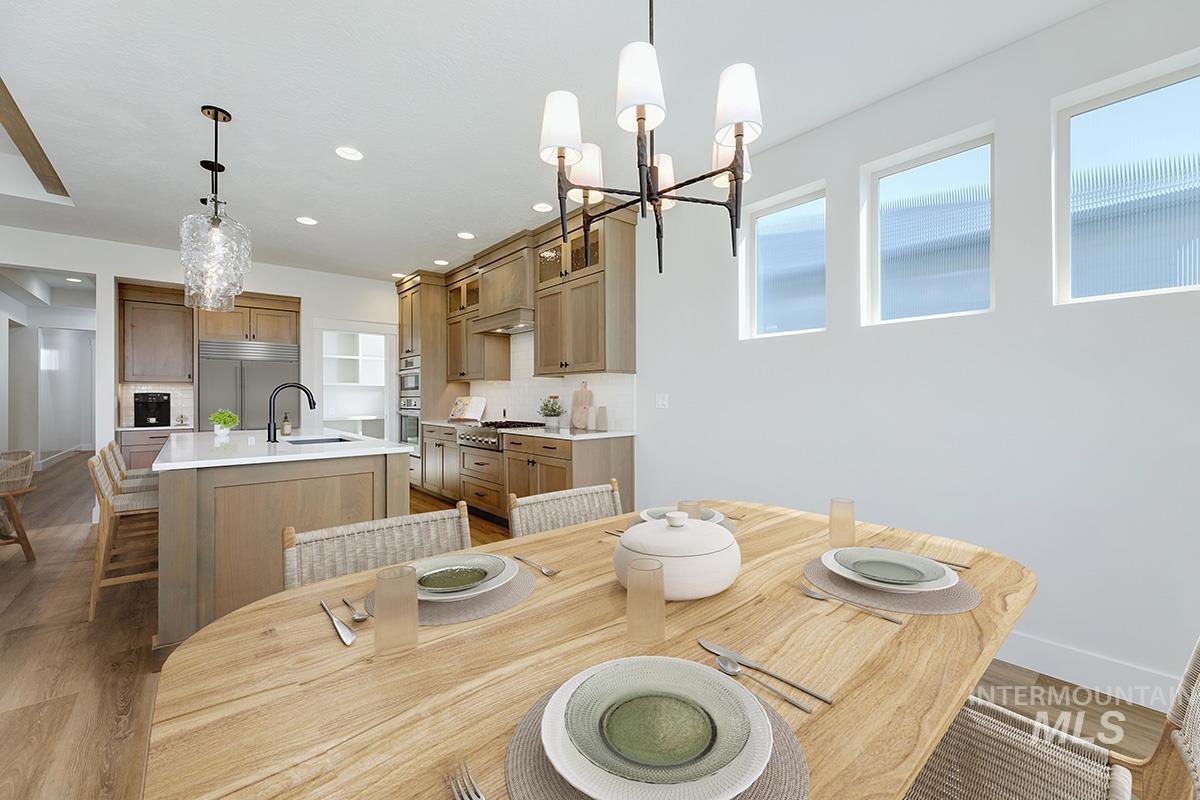 Dining room with a chandelier, recessed lighting, and light wood-style flooring