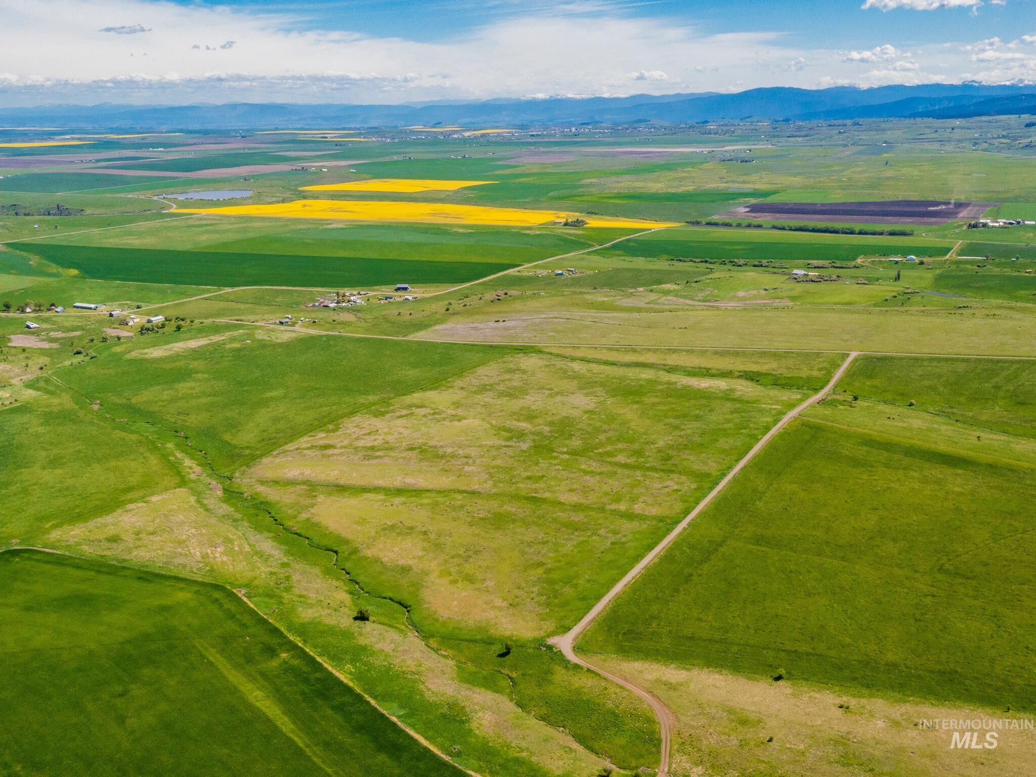 Aerial view of sparsely populated area with a mountain backdrop and extensive farmland