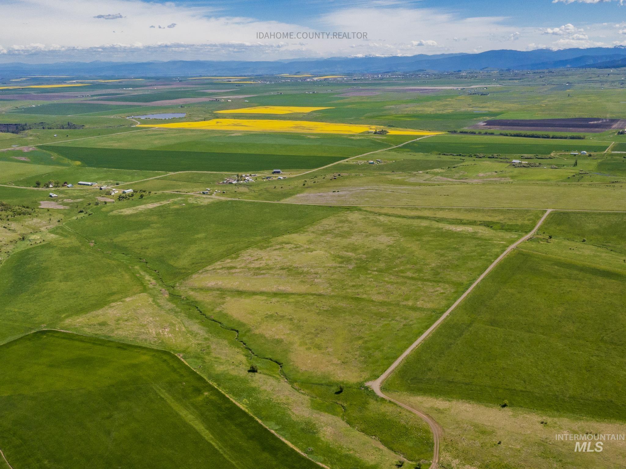 Aerial view of sparsely populated area featuring a mountainous background and extensive farmland