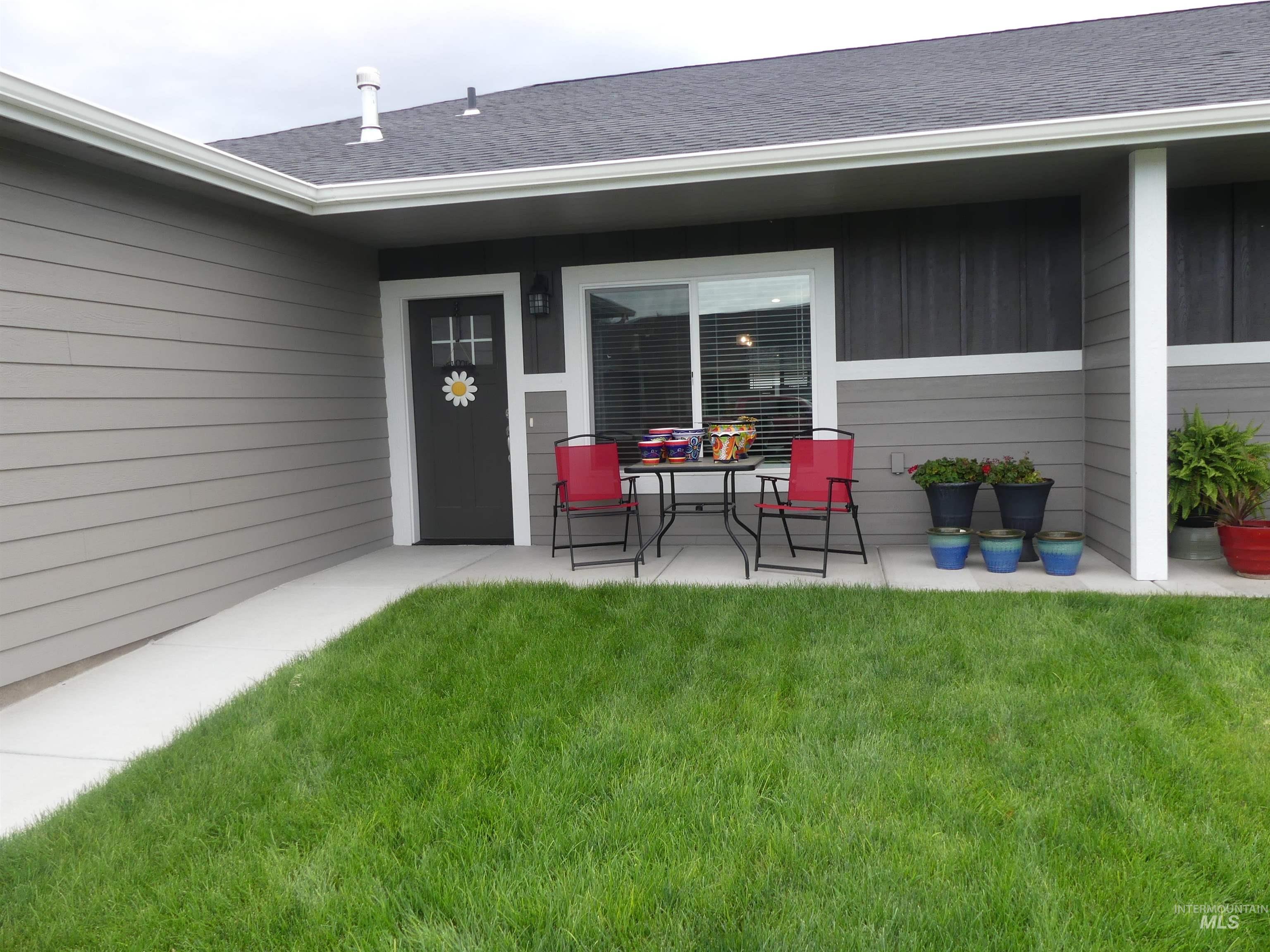 Property entrance with a lawn and roof with shingles