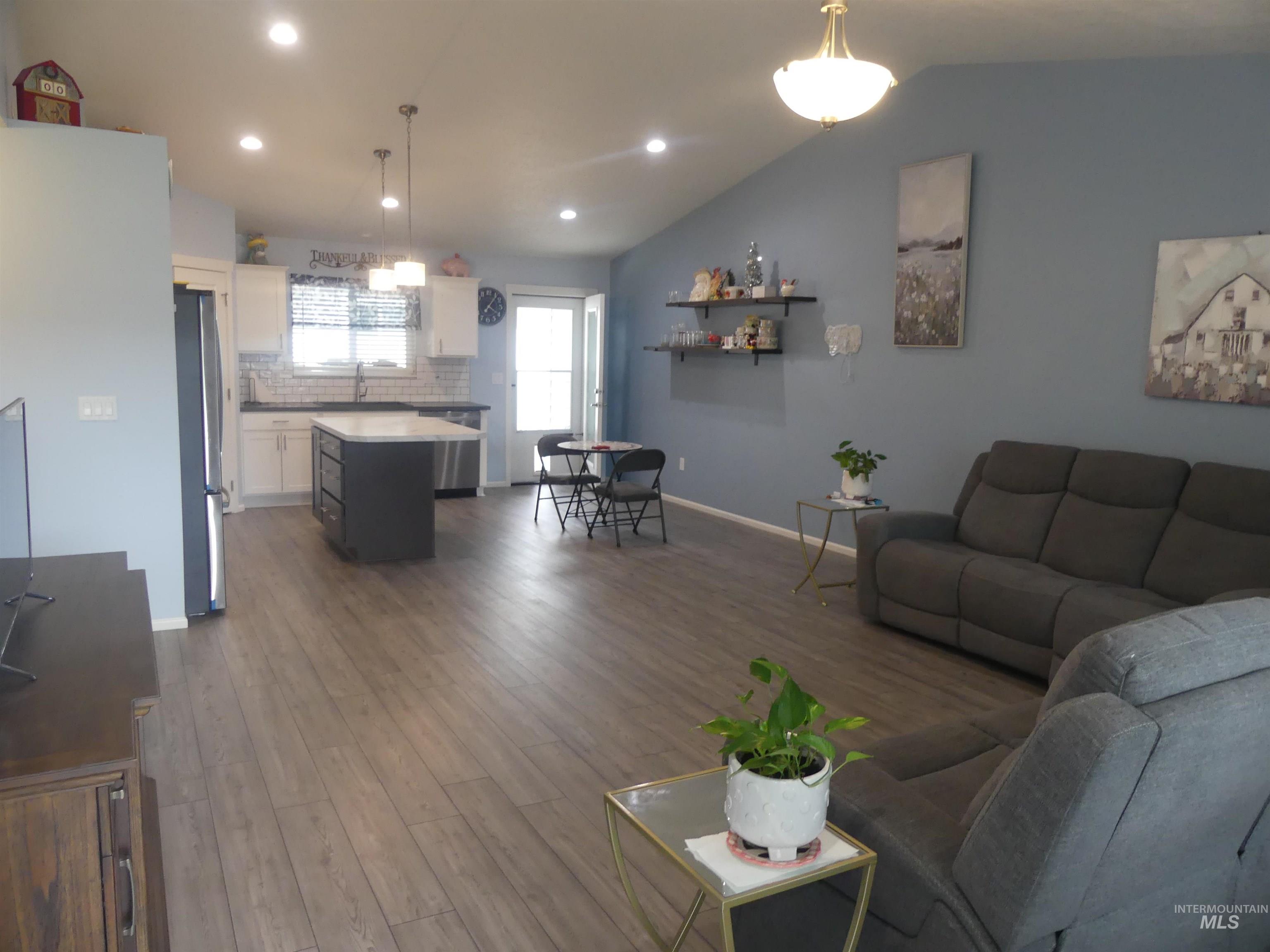 Living area with recessed lighting, dark wood-type flooring, and vaulted ceiling