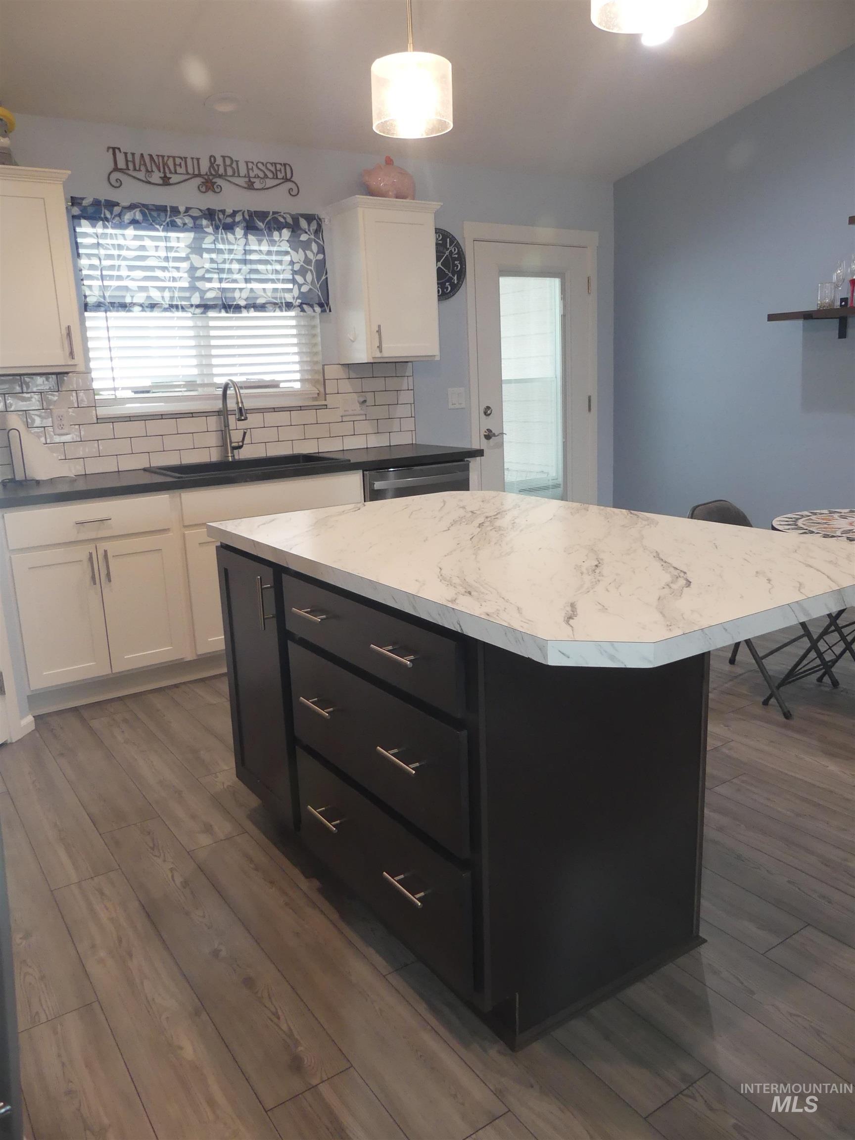 Kitchen with dark countertops, tasteful backsplash, dark cabinetry, and a kitchen island